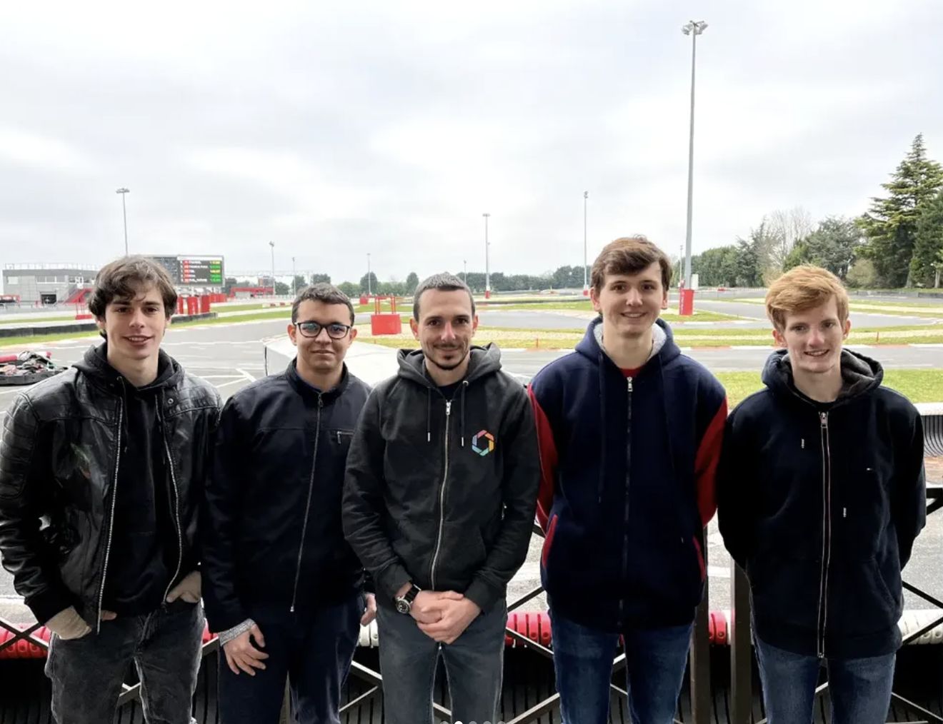 Les pilotes de l'équipe de course devant le circuit